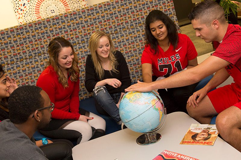 Students looking at a globe